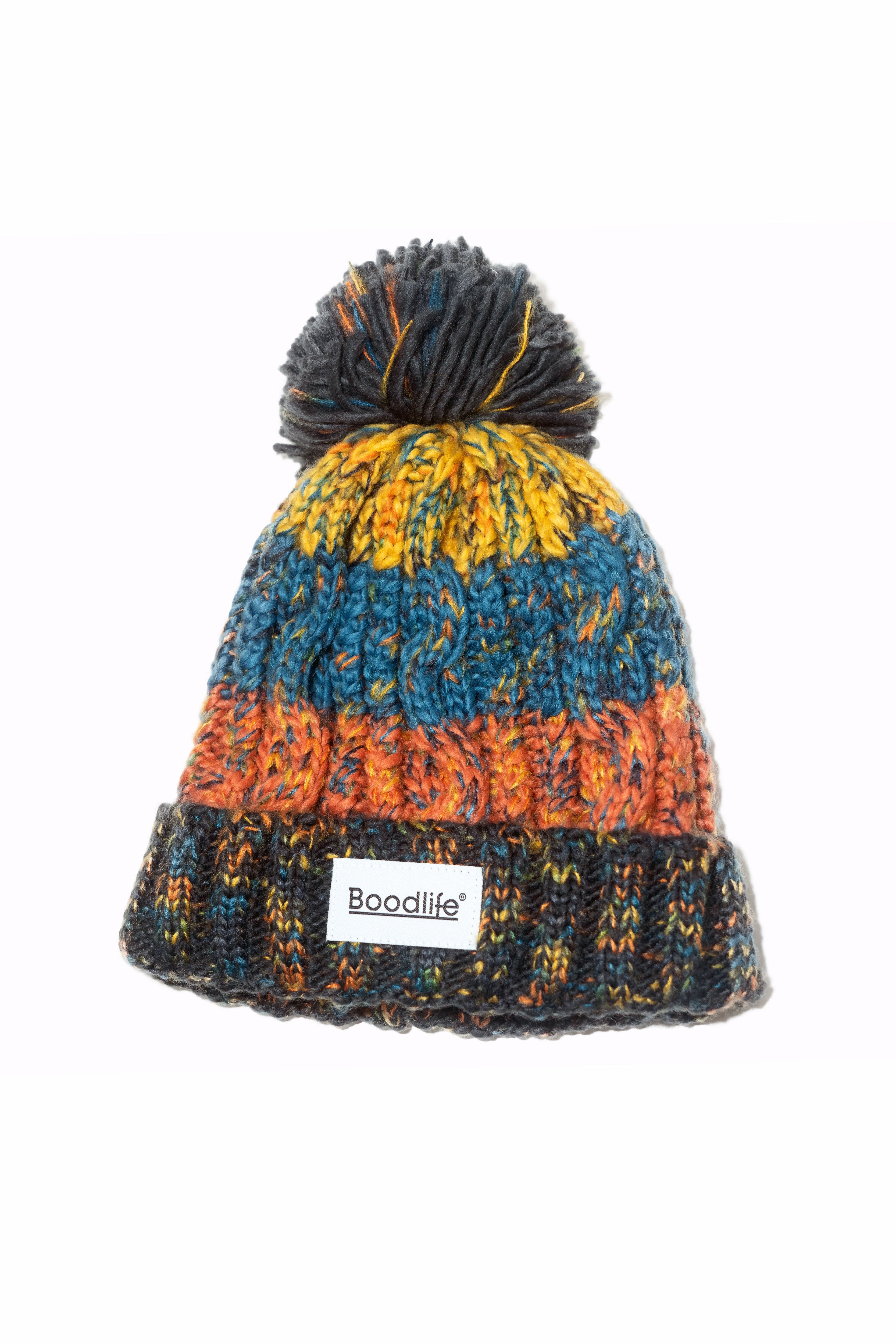 Gorro Landscape de Boodlife: punto grueso con pompón azul marino y franjas en mostaza, azul petróleo y naranja